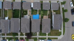 A residential block featuring multiple properties with uniform gray shingle roofs - 