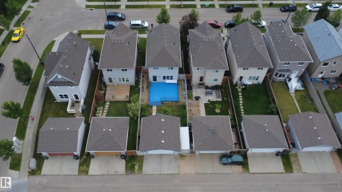 Rear yard featuring a blue-lined pool with surrounding deck, adjacent to a structured patio area - 1528 35 Avenue Nw, Edmonton, AB - Outdoor With View