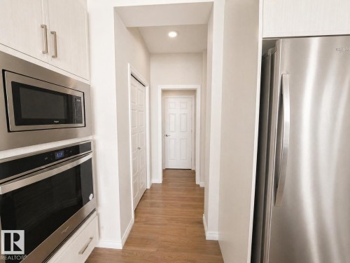 Kitchenette featuring stainless steel refrigerator, microwave, and built-in oven - 1327 20 Nw, Edmonton, AB - Indoor Photo Showing Kitchen