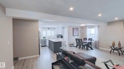 Open-concept common area featuring wood-finish flooring, recessed lighting, and a neutral color palette - 