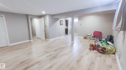 Expansive room featuring light wood-finish flooring, recessed lighting, and pale gray wall finishes - 