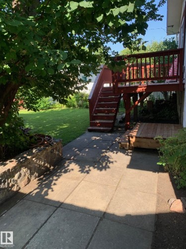 Elevated wooden deck with stairs leading to a ground-level patio - 16321 - 109A Ave Nw, Edmonton, AB - Outdoor