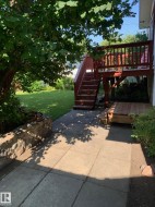 Elevated wooden deck with stairs leading to a ground-level patio - 