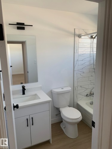 Modern bathroom featuring a white vanity with quartz countertop, undermount sink, and matte black faucet - 16321 - 109A Ave Nw, Edmonton, AB - Indoor Photo Showing Bathroom