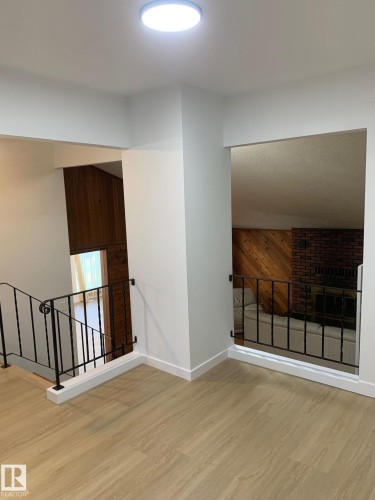 Open loft area featuring light wood-finish flooring, white walls, and a contemporary flush-mount ceiling light - 16321 - 109A Ave Nw, Edmonton, AB - Indoor Photo Showing Other Room