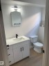 Bathroom featuring a white vanity with matte black hardware, integrated sink, and white countertop - 16321 - 109A Ave Nw, Edmonton, AB  - Indoor Photo Showing Bathroom 
