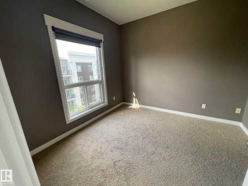 Expansive window with white trim and a roller shade - 504 10518 113 Street, Edmonton, AB - Indoor Photo Showing Other Room