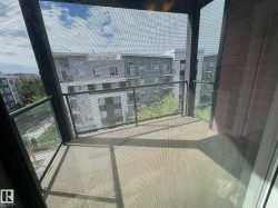 Outdoor balcony featuring a concrete floor and black metal railings with glass panels - 