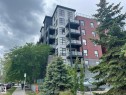 Multi-story building featuring a brick and panel facade, multiple balconies with glass railings, and ground-level commercial frontage - 504 10518 113 Street, Edmonton, AB  - Outdoor With Balcony With Facade 