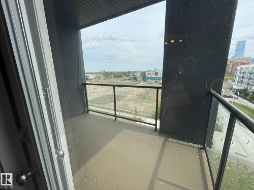 Private balcony with a concrete floor, glass and metal railings, and a wood-panel ceiling - 504 10518 113 Street, Edmonton, AB - Outdoor With Balcony