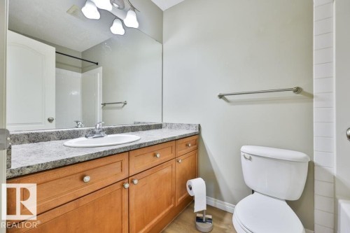 Bathroom vanity featuring a light-toned stone-look countertop with an integrated sink and chrome faucet - #406 4903 47 Av, Stony Plain, AB - Indoor Photo Showing Bathroom