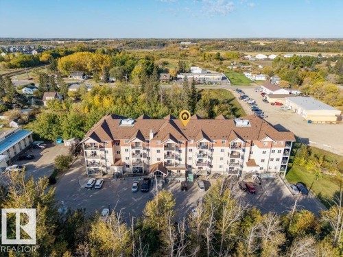 Multi-story residential building featuring a brown shingle roof and light-toned exterior siding - #406 4903 47 Av, Stony Plain, AB - Outdoor With View