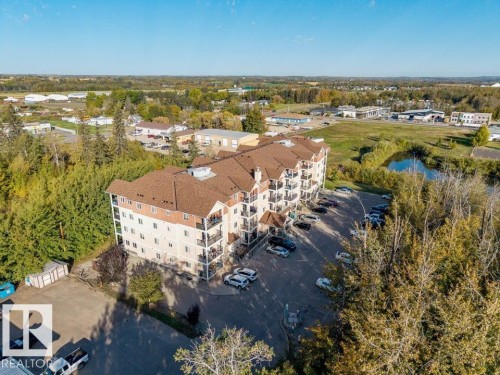 Multi-story building featuring a brown shingle roof and light-toned siding - #406 4903 47 Av, Stony Plain, AB - Outdoor With View