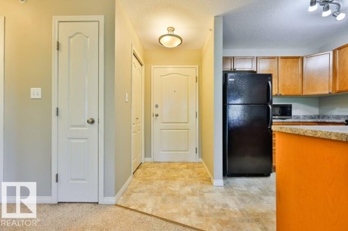 Entryway with neutral wall paint and a flush-mount light fixture - #406 4903 47 Av, Stony Plain, AB - Indoor Photo Showing Kitchen