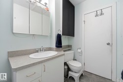Bathroom vanity with a white oval sink, chrome faucet, and gray countertop - 