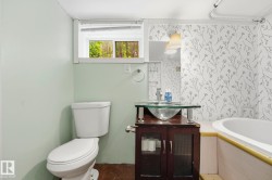 Bathroom featuring a white toilet, frosted window, and a vanity with a glass vessel sink - 