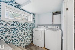 Dedicated laundry area featuring a patterned chevron tile accent wall, a fixed window with blinds, and a built-in white shelf - 