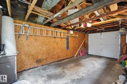 Single-bay garage featuring an overhead door and exposed wood beam ceiling - 