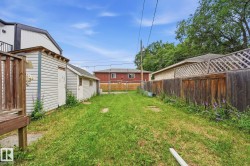 Expansive grassy yard area with a shed featuring vinyl siding - 
