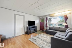 Living area featuring wood-finish flooring, white walls, and a large window with transom panels - 