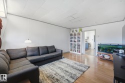 Living area featuring wood-finish flooring, light grey walls, and white trim - 