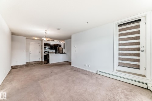 Open-concept living space with plush carpeting and a neutral color palette - 103 3315 James Mowatt Trail Sw, Edmonton, AB - Indoor Photo Showing Other Room