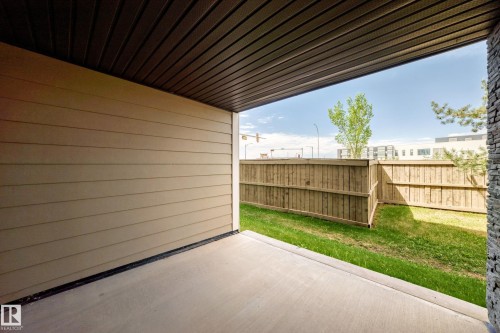 Covered concrete patio with horizontal siding and a dark soffit ceiling - 103 3315 James Mowatt Trail Sw, Edmonton, AB - Outdoor With Exterior