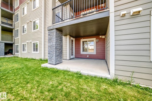 Ground-level patio with concrete flooring, accented by a stone-clad pillar - 103 3315 James Mowatt Trail Sw, Edmonton, AB - Outdoor With Balcony With Exterior