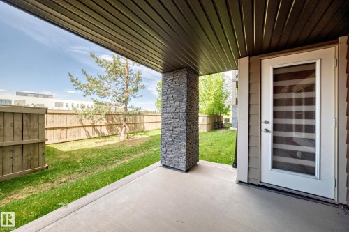 Covered patio with concrete flooring, accented by a stone pillar - 103 3315 James Mowatt Trail Sw, Edmonton, AB - Outdoor With Deck Patio Veranda With Exterior