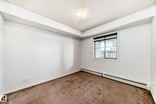 Neutral wall paint with baseboard trim, window with blinds, and ceiling-mounted light fixture - 103 3315 James Mowatt Trail Sw, Edmonton, AB - Indoor Photo Showing Other Room