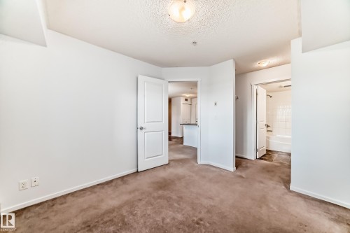Carpeted room with white walls and a ceiling-mounted light fixture - 103 3315 James Mowatt Trail Sw, Edmonton, AB - Indoor Photo Showing Other Room