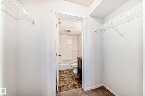 Walk-in closet featuring white wire shelving - 103 3315 James Mowatt Trail Sw, Edmonton, AB - Indoor Photo Showing Bathroom
