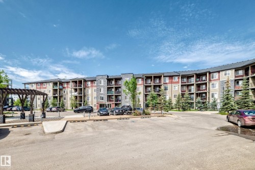 Multi-story residential building featuring balconies, stone accents, and varied facade colors - 103 3315 James Mowatt Trail Sw, Edmonton, AB - Outdoor With Balcony With Facade