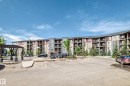 Multi-story residential building featuring balconies, stone accents, and varied facade colors - 103 3315 James Mowatt Trail Sw, Edmonton, AB  - Outdoor With Balcony With Facade 