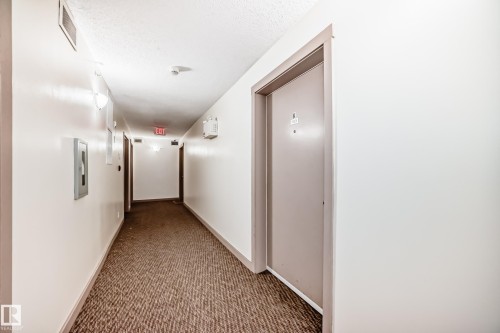 Hallway with neutral tone walls and brown patterned carpet - 103 3315 James Mowatt Trail Sw, Edmonton, AB - Indoor Photo Showing Other Room