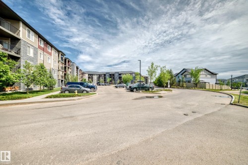 Modern multi-story building featuring balconies and a combination of siding and stone finishes - 103 3315 James Mowatt Trail Sw, Edmonton, AB - Outdoor