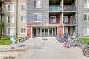 Building exterior featuring a stone facade and beige siding - 103 3315 James Mowatt Trail Sw, Edmonton, AB  - Outdoor With Balcony With Facade 