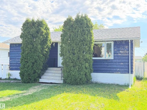 Single-story residence featuring blue siding, a white front door, and a white-framed window - 4823 49 Street, Clyde, AB - Outdoor
