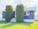 Single-story residence featuring blue siding, a white front door, and a white-framed window - 4823 49 Street, Clyde, AB  - Outdoor 