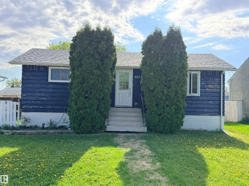 Single-story residence featuring a blue exterior siding, white trim windows, and a classic white entry door with a house number - 4823 49 Street, Clyde, AB - Outdoor