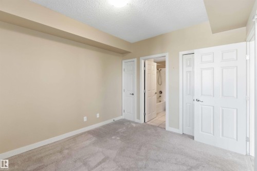 Neutral-toned walls complement the light gray carpet flooring - #708 9939 109 St Nw, Edmonton, AB - Indoor Photo Showing Other Room