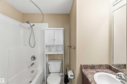Bathroom featuring a white tub and shower combination with a handheld showerhead - 