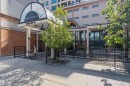 Building exterior featuring a domed glass entryway, prominent signage, and a paved sidewalk - #708 9939 109 St Nw, Edmonton, AB  - Outdoor 
