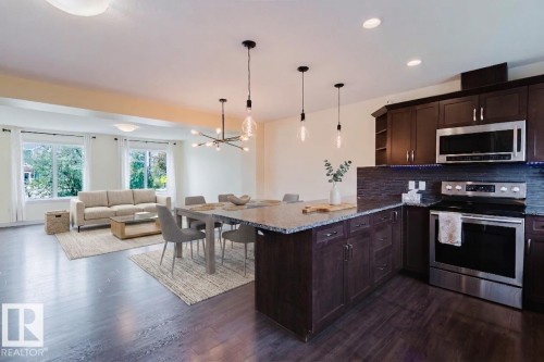 Open-concept living space featuring dark wood-finish flooring - 6717 Elston Lane Nw, Edmonton, AB - Indoor Photo Showing Kitchen