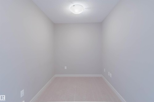 Neutral-toned room featuring a flush-mount ceiling light fixture, light gray wall paint, white baseboards, and soft carpet flooring - 6717 Elston Lane Nw, Edmonton, AB - Indoor Photo Showing Other Room