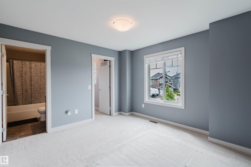 Carpeted room with a double-pane window and a flush-mount ceiling light - 6717 Elston Lane Nw, Edmonton, AB - Indoor