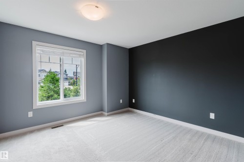 Room featuring gray wall finishes, a single accent wall, white trim, and light-toned carpet flooring - 6717 Elston Lane Nw, Edmonton, AB - Indoor Photo Showing Other Room