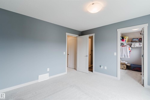 Bedroom featuring light gray walls, white trim, and light-colored carpet flooring - 6717 Elston Lane Nw, Edmonton, AB - Indoor