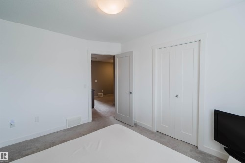 Neutral-toned carpeting paired with white walls - 6717 Elston Lane Nw, Edmonton, AB - Indoor Photo Showing Bedroom
