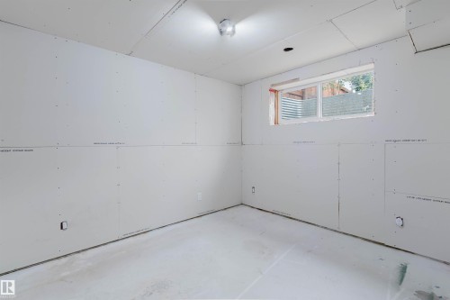 Unfinished room featuring drywall-installed walls and ceiling, a single window, and concrete flooring - 6717 Elston Lane Nw, Edmonton, AB - Indoor Photo Showing Garage